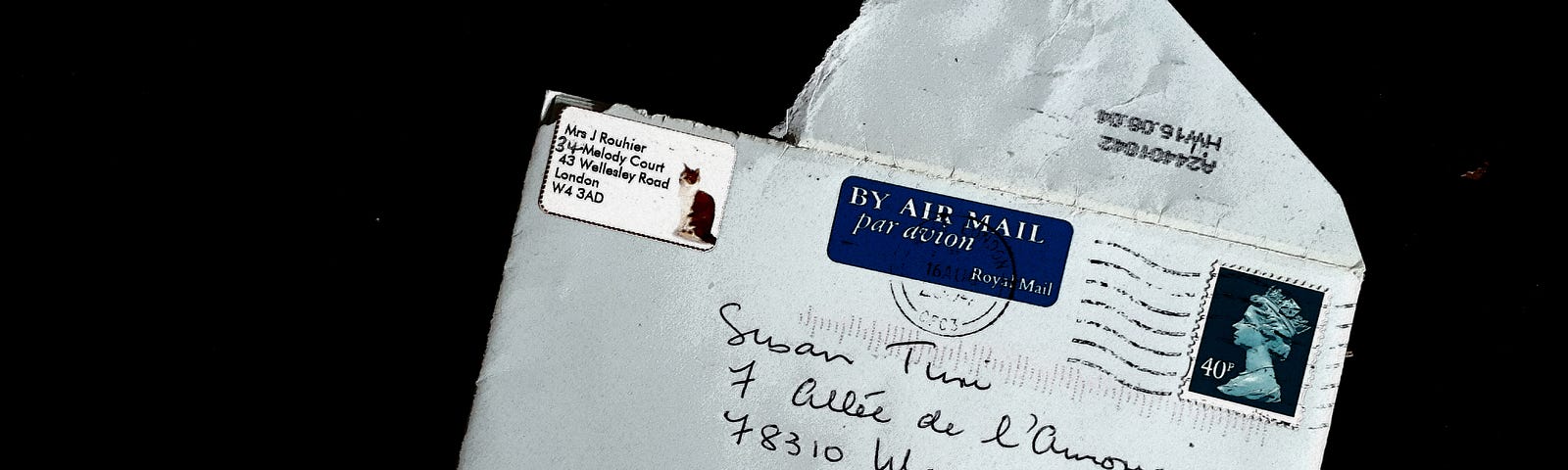 An open white envelope with an address from France on it.