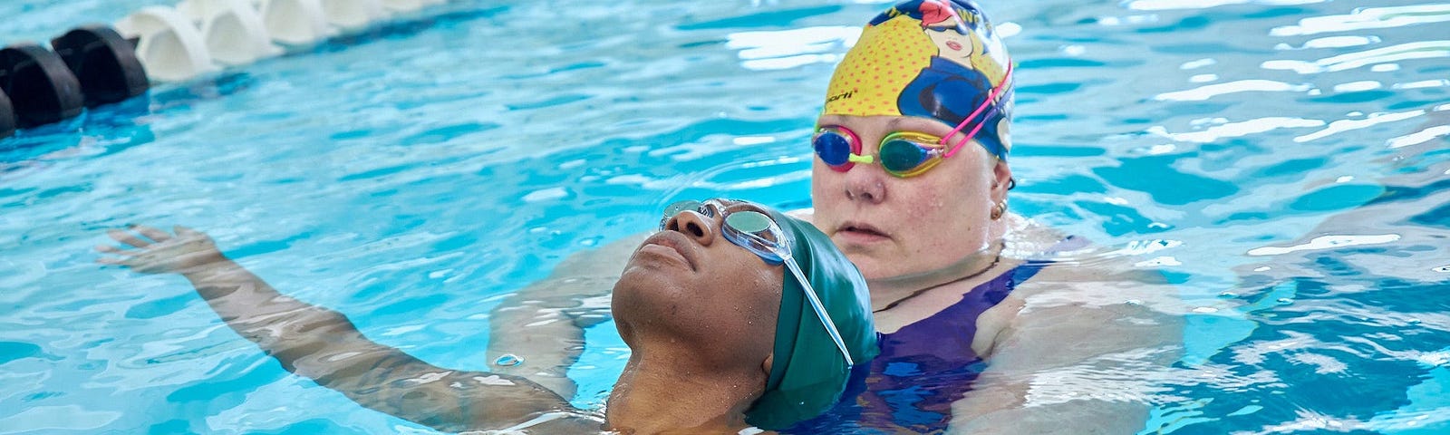 Aaricka Washington being supported in a pool by a swim instructor.