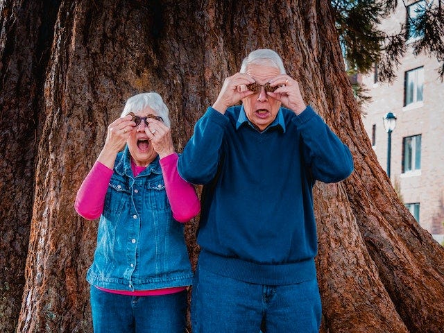 An older couple putting on strange sunglasses.