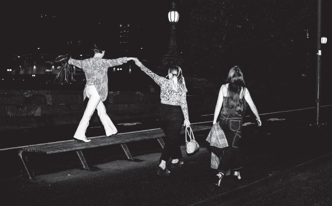 A trio of young women walk home after a night out.