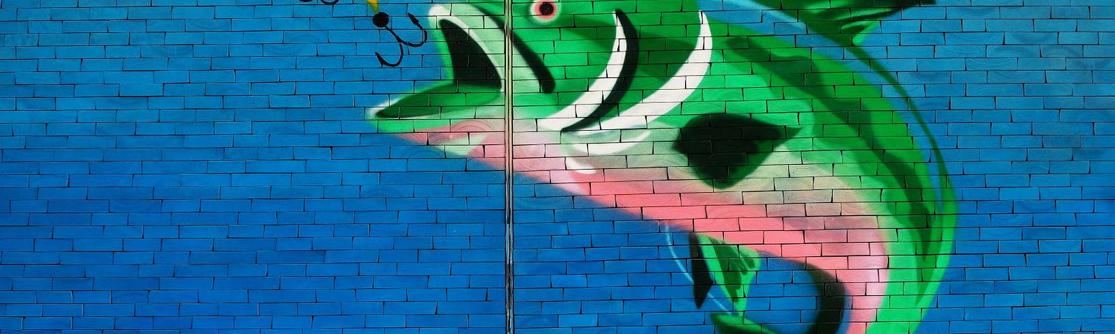 A mural showing a large green fish about to swallow a fishing hook.
