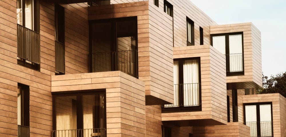 Picture of a house with a wooden facade, with cubicles protruding out of the house.