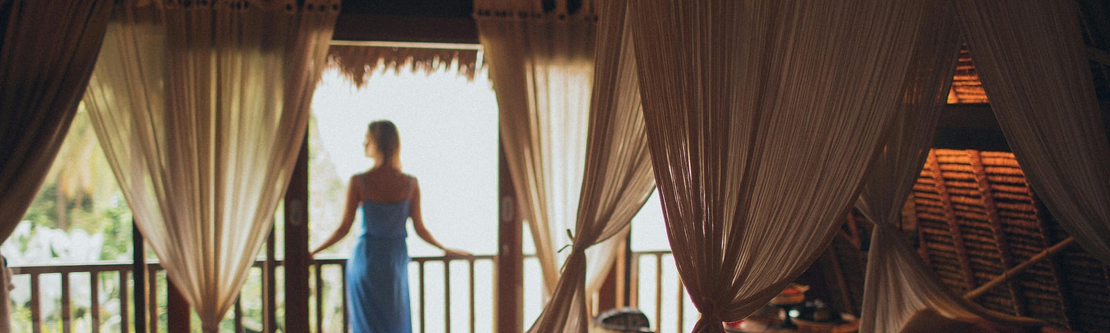 A woman looking out on the balcony of her relaxing hotel room optimised for restful sleep