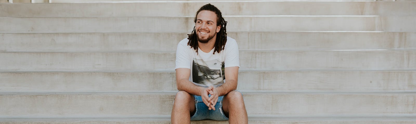 young man sitting on stairs laughing