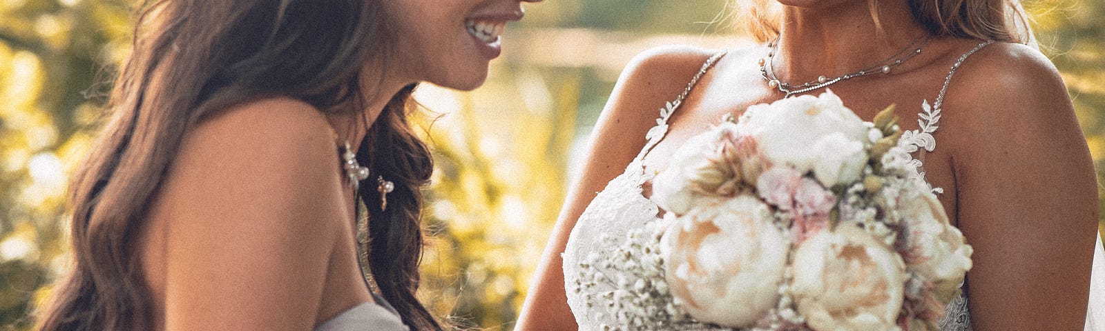A bride and bridesmaid share a laugh