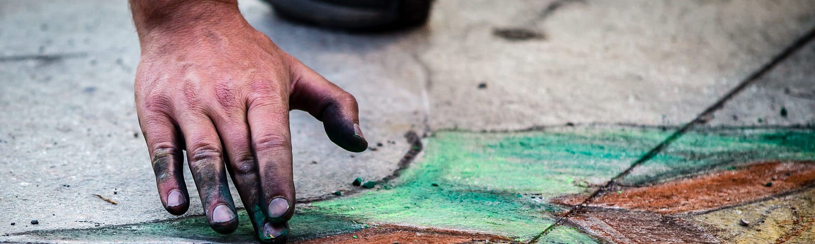 Photographie de la main d’un artiste de rue, dessinant