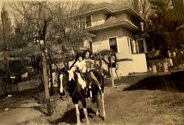 The author and a sister sitting on the horse, Little Miss in the early 1960s. Their 1920’s stucco house is in the background, and grape arbor to the left.