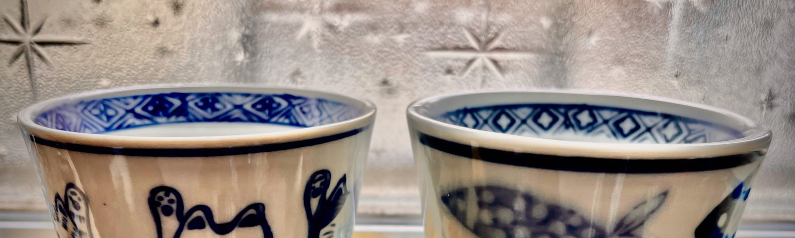 A pair of Japanese ceramic cups with cute animal (cat and fish) patterns