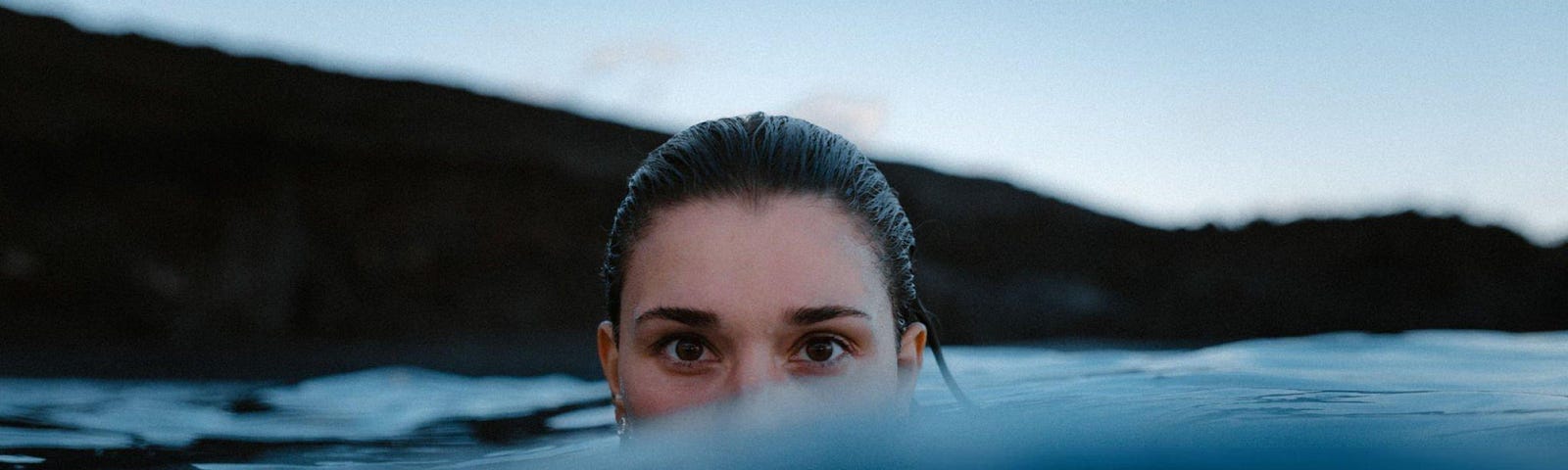 Portrait Of Woman Swimming In Sea Against Sky stock photo