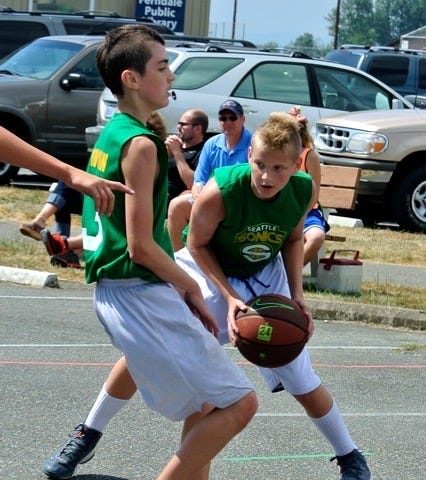 A young Drew McFall plays basketball in a parking lot.