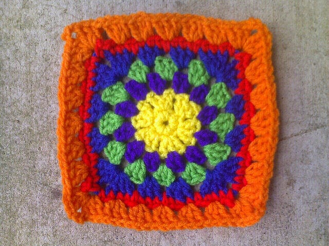 A multi color granny square that starts with a crochet circle in the center, but is squared off by the seventh round