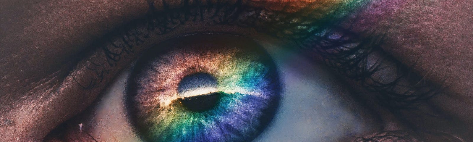 A close-up of an eye with a rainbow stripe of light overlapping it.