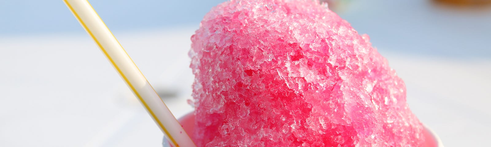 pink shaved ice snow cone in paper cup