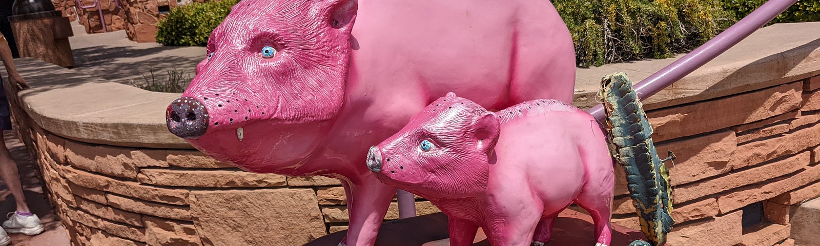 Statue of two bright pink javalinas