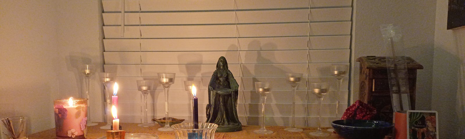 A pagan alter with candles and a statue