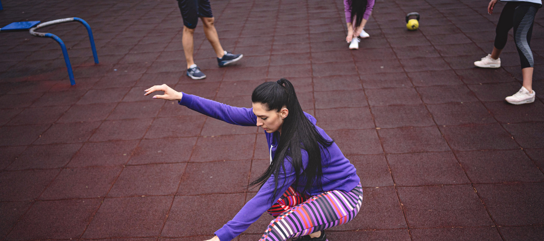 woman performing single leg squat while holding onto her extended foot