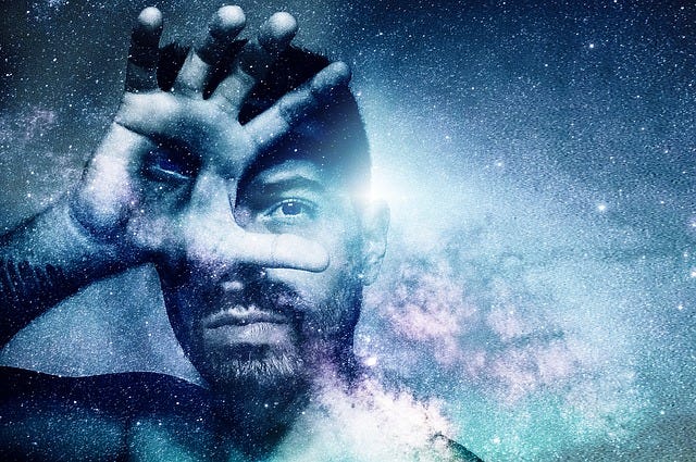 Man with dark hair and a beard shields face with his hand, an eye is located in his palm, background is cosmic lights