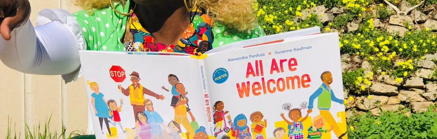 Drag queen reading “All are Welcome”