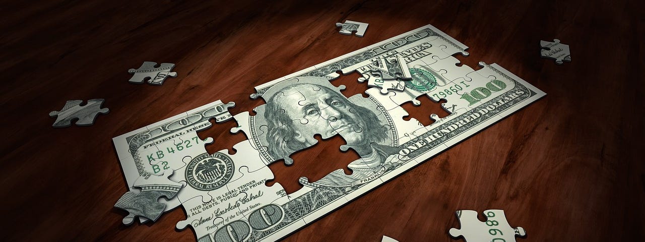 A puzzle with image and shape of a 100 dollar bill, with some pieces scattered around.