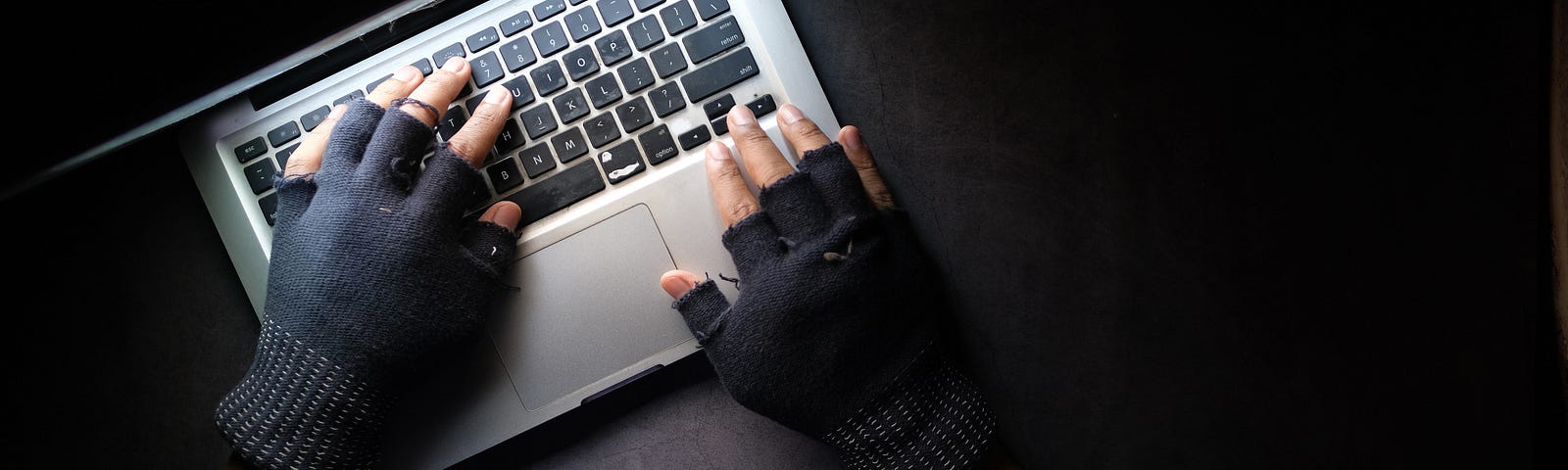 A Person Typing on Laptop while Wearing a Fingerless Gloves