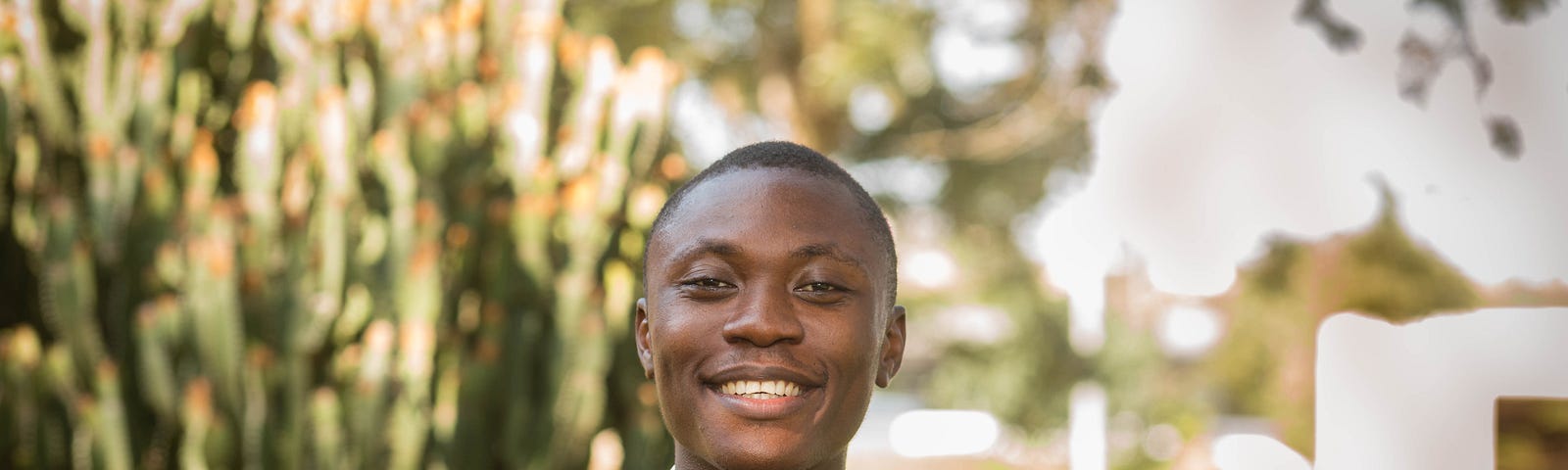 Image of Boateng Sekyere standing in front of some cacti trees