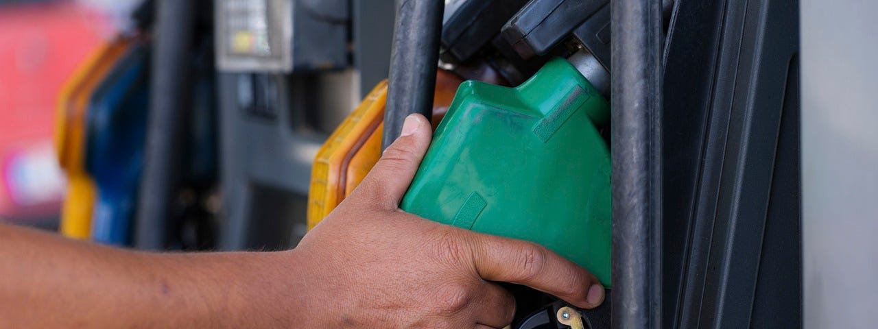 IMAGE: A hand picking an fuel hose in a petrol station