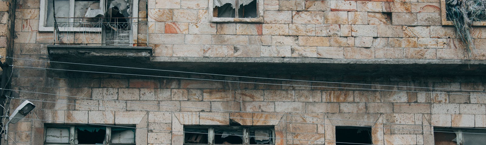 An old building that looks abandoned with many windows broken