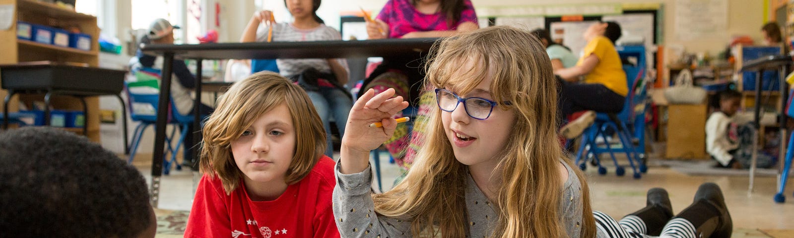 Three students work together in a classroom.