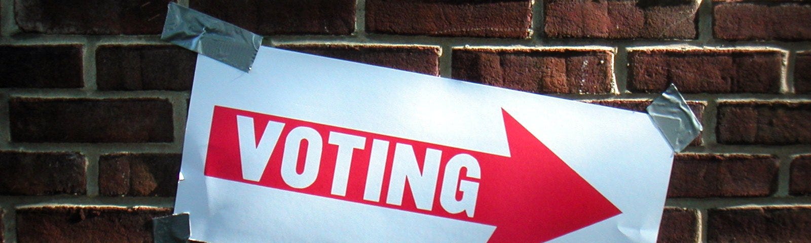 Voting sign taped to a wall. Courtesy Keith Ivey via flickr.