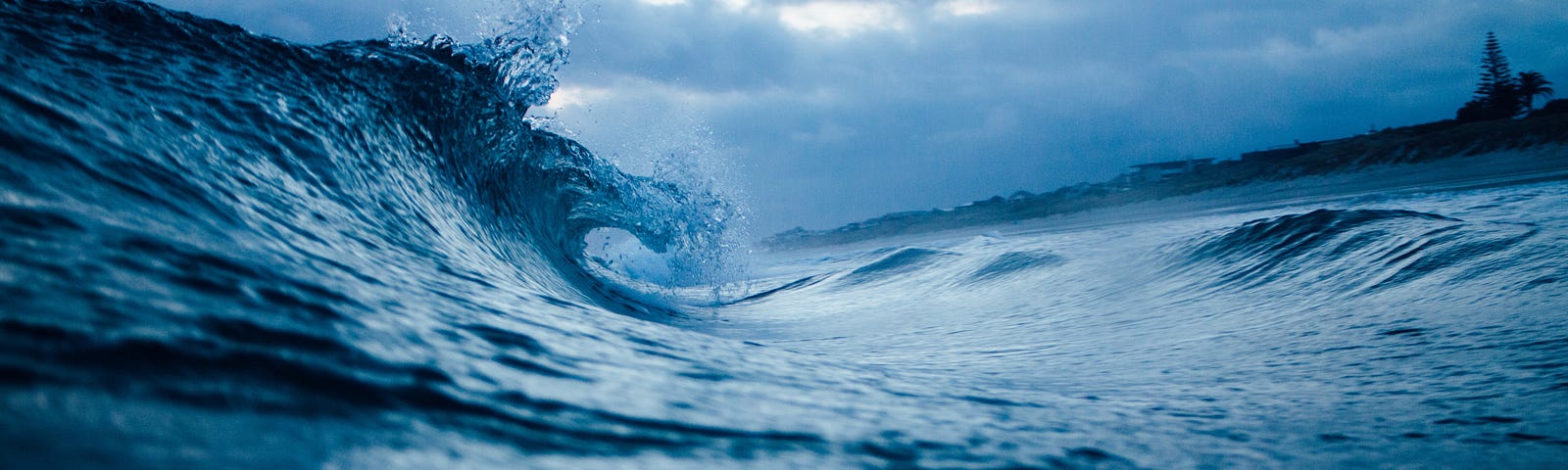 A large ocean wave breaks as it’s heading to shore.
