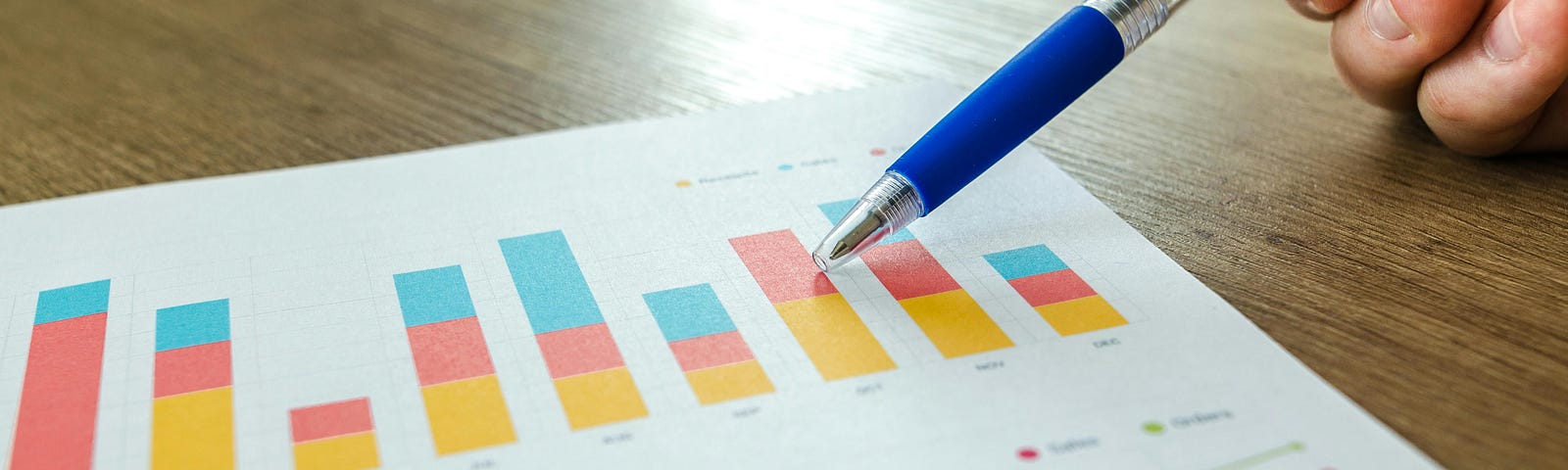 Person Holding Pen Pointing at Graph