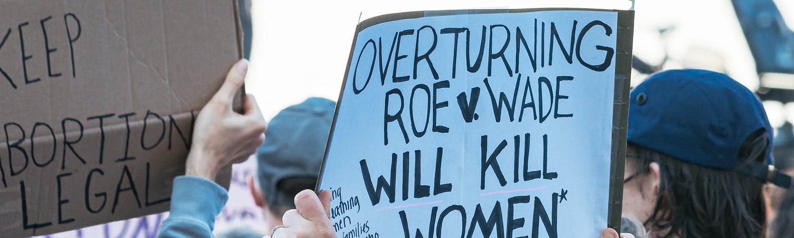 IMAGE: Signs at a demonstration reading “Keep abortion legal” and “Overturning Roe v. Wade will kill women”
