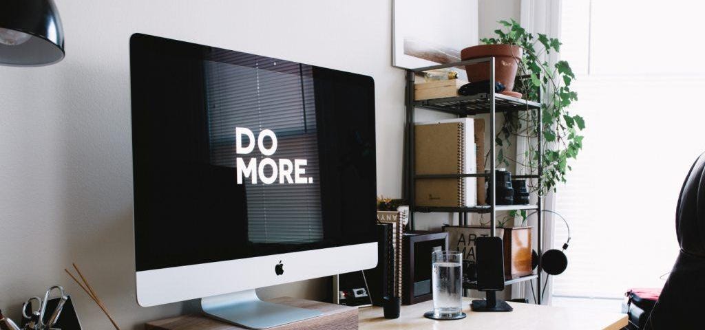 A PC on the desk. On the screen is written Do more.