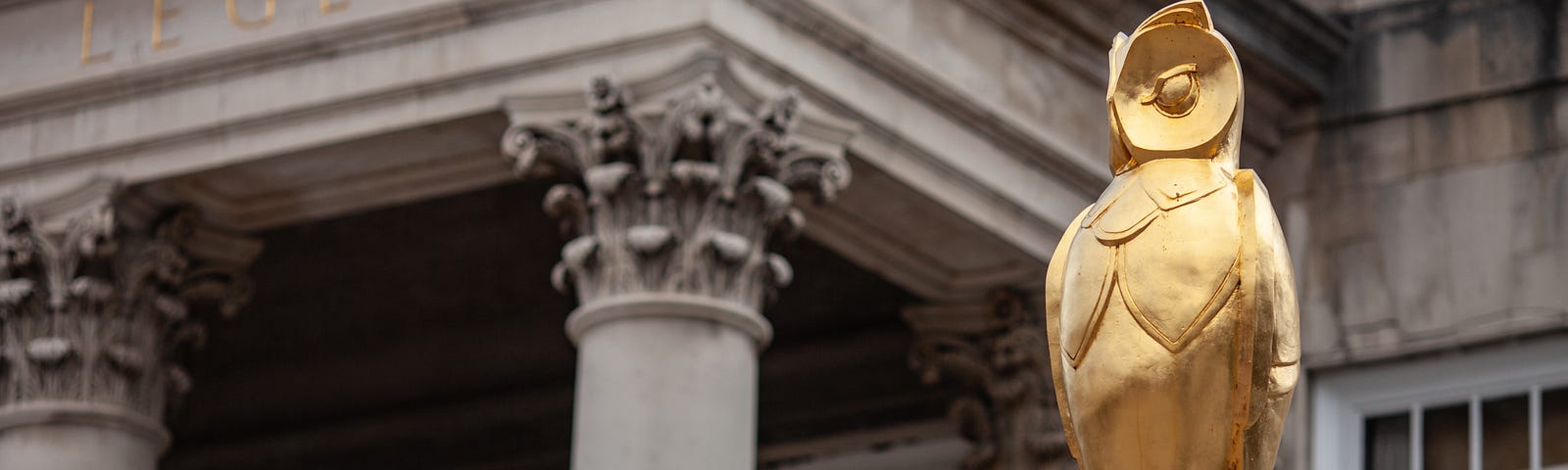 Golden owl statue in front of a historic Leeds building