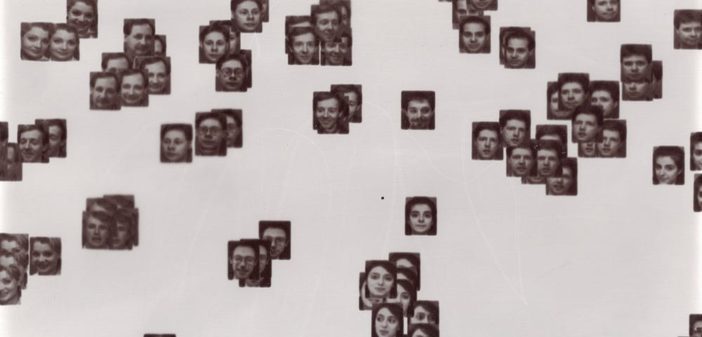 Black and white photographs  of the faces of White people scattered across a white background and grouped by similarity.