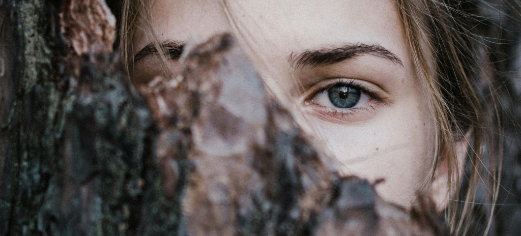 woman looking through leaves