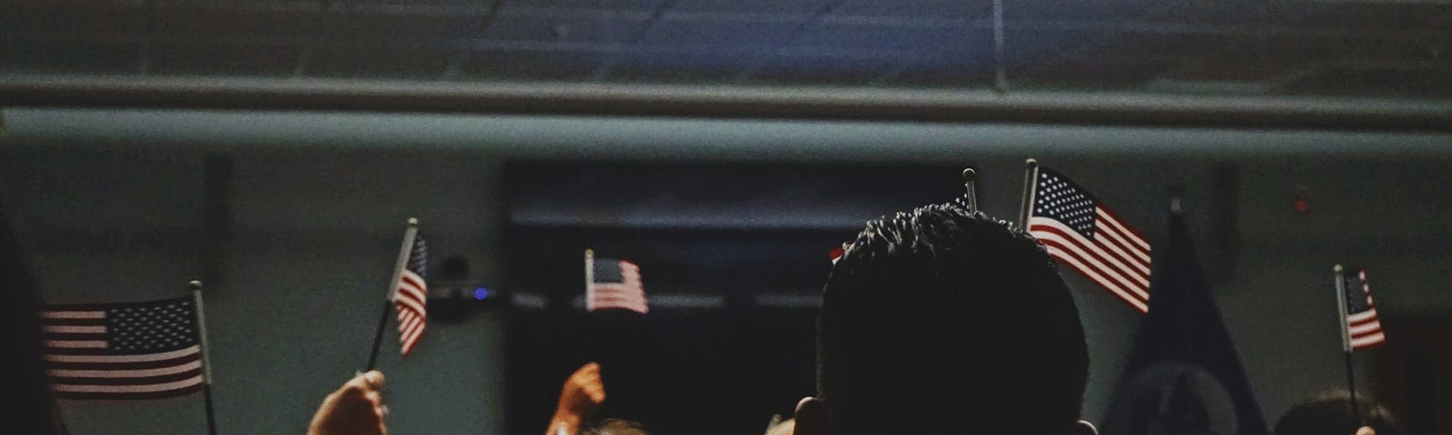 A crowd of people waving small American flags