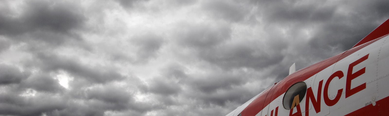 An air ambulance beneath cloudy skies.