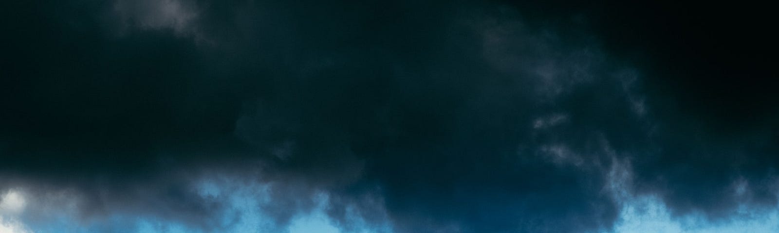 Silhouette of the Eiffel Tower in Paris against a backdrop of dark clouds.