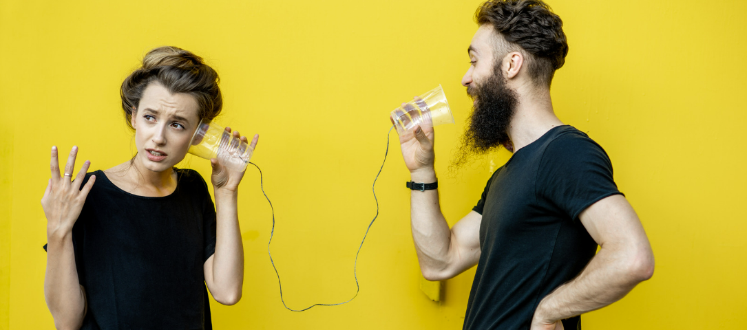 A man and woman communicating effectively through cups with yellow background