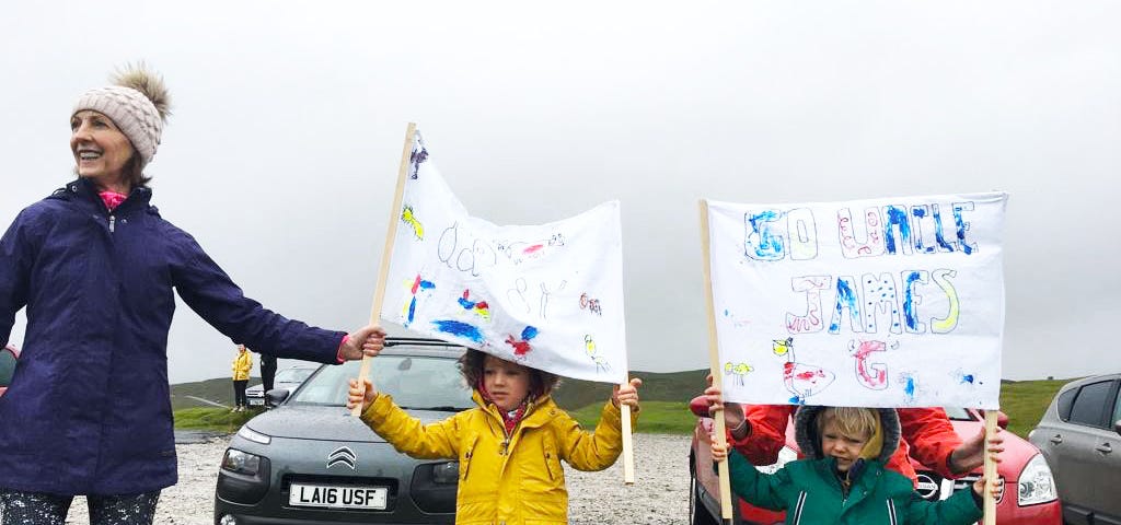 Liam’s family cheering him on from the side of the track, holding up banners in the cold, grey weather.