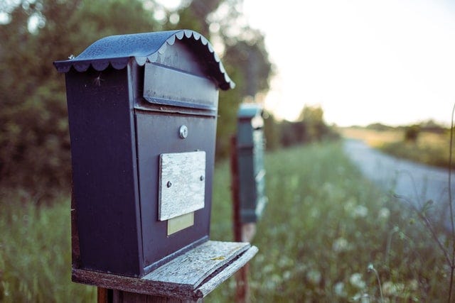 A mailbox on the side of a country road.