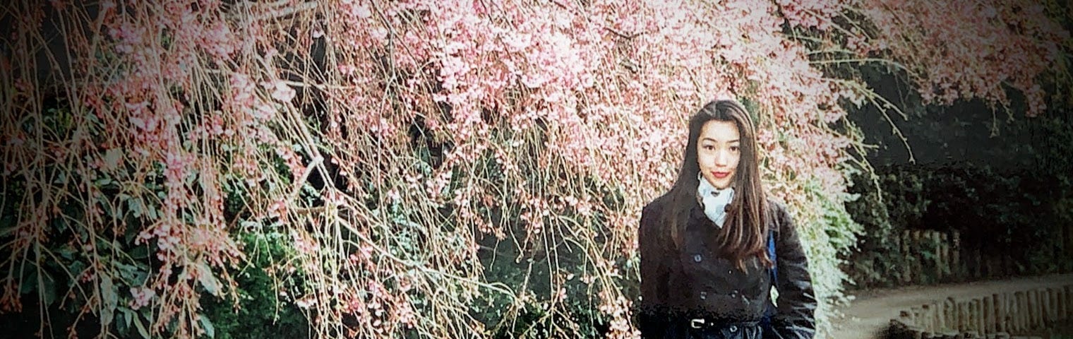 A photo of my wife under a cherry blossom tree