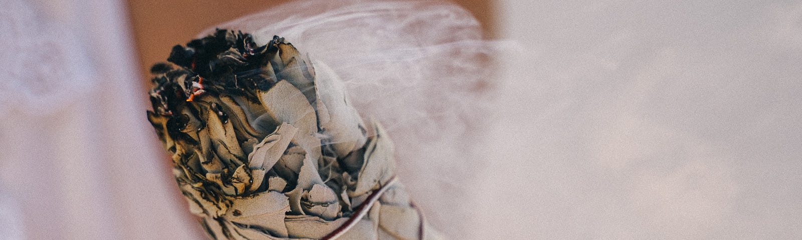 woman holding burning white sage