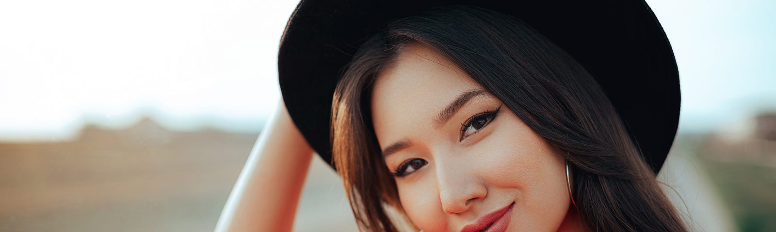 A female creator in a red top and black hat