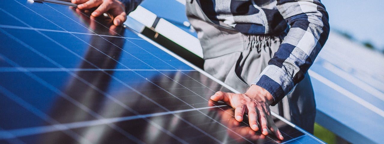 IMAGE: A worker revising a solar panel installation