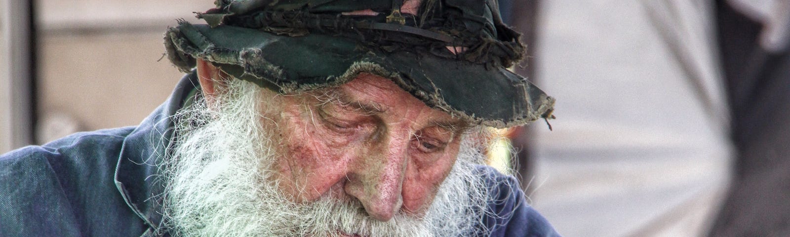An elderly writer wearing a full set of grey beard