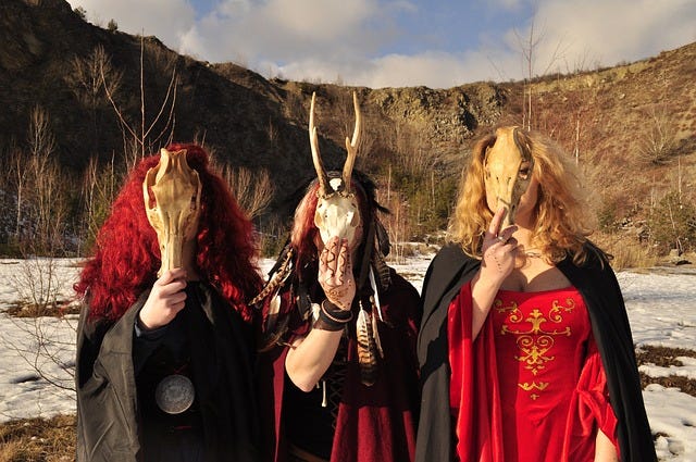 Photo of three priestesses donning animal skull masks