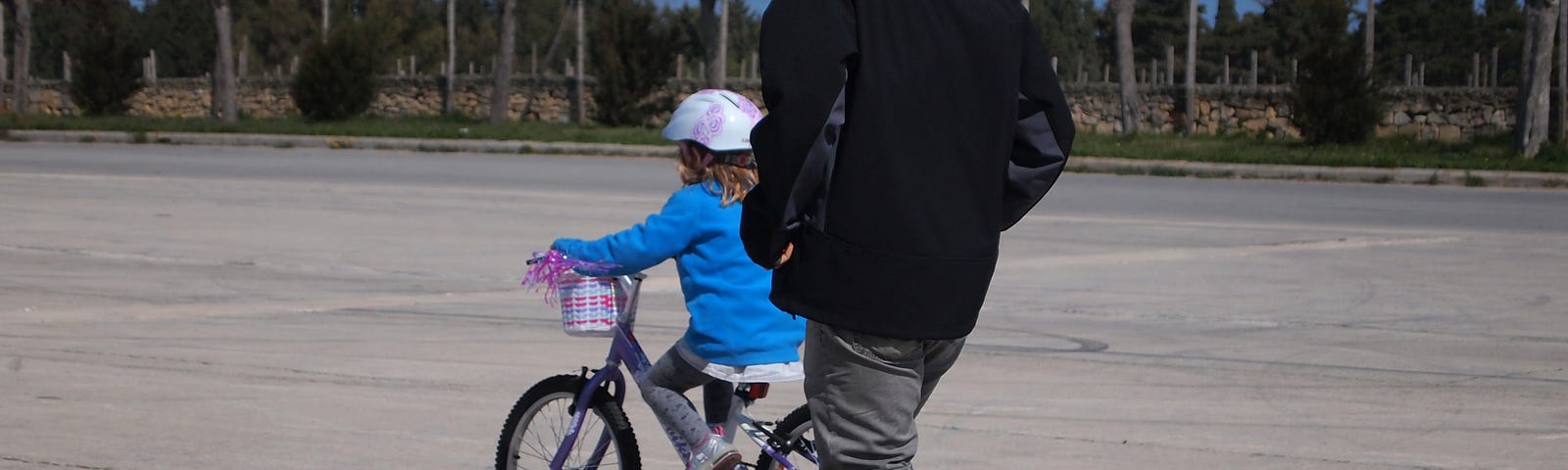a kid on a bike and an adult running behind her. Photo by the author. All copyrights reserved