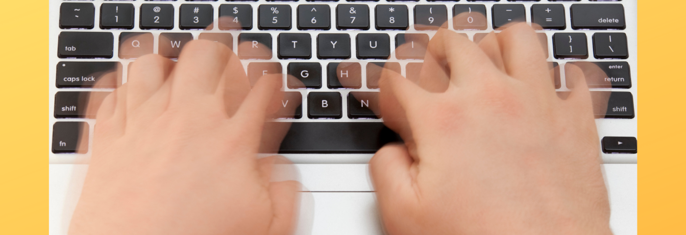 Blurry hands typing fast on laptop keyboard